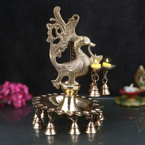 A stunning Brass Peacock Diya Hanging with Bells, featuring a graceful peacock design with a shiny brass finish.  Indiaβs Largest Pooja Accessories Brand β www.satvikstore.in