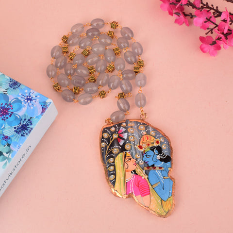Beautifully hand-painted agate necklace featuring Lord Radha and Krishna, crafted with vibrant detailing on a natural semi-precious stone pendant. India’s Largest Pooja Accessories Brand – www.satvikstore.in